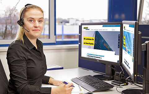 Büroarbeitsplatz mit Computer Mitarbeiterin von Streck Transport Freiburg arbeitet am Computer und spricht in ein Headset